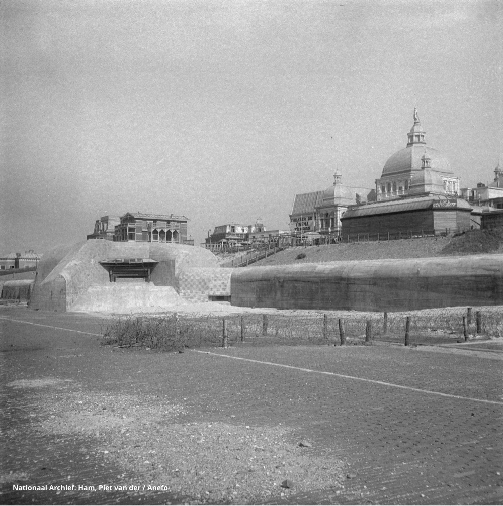 De boulevard van Scheveningen is verlaten en dichtgetimmerd. Voor het Kurhaus is een bunker en tankmuur gebouwd. - Foto: Nationaal Archief, fotograaf Ham, Piet van der / Anefo